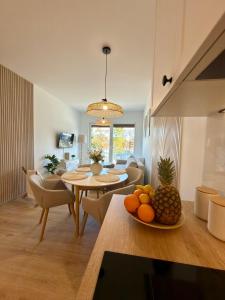 a living room with a table and a dining room at Apartament Boho Let's Sea Gąski in Gąski