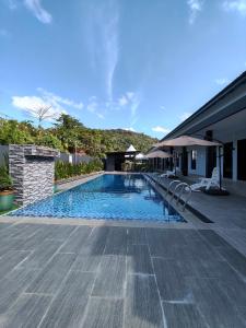 a swimming pool next to a house at Rimba Inn in Kijal