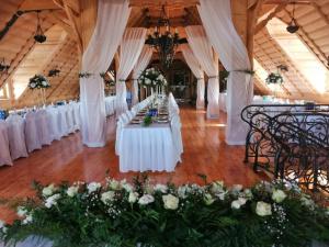 a row of tables in a room with white flowers at Dwór Kresowy in Radymno +40 photos