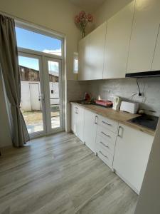 a kitchen with white cabinets and a large window at Sweet Home in Dilijan