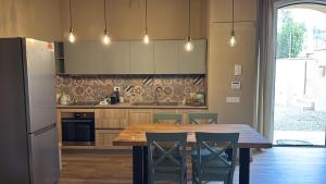 a kitchen with a table and chairs and a refrigerator at Podere Gorette in Poggibonsi
