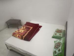 a white bed with two pillows on top of it at Chohan guest house in Khātu