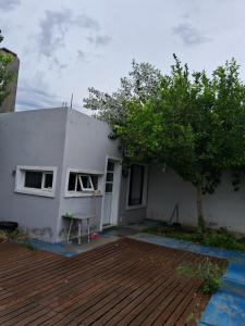 a white house with a tree in front of it at Complejo FE LE SA in Las Grutas