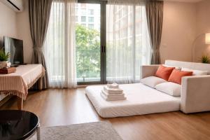 a living room with a white couch and a large window at 1Bedroom+Sofa bed, Luxury Condo@Nimmana in Chiang Mai