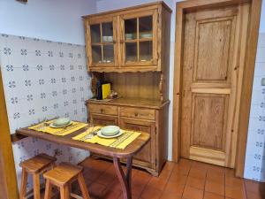 a kitchen with a wooden table and two stools at Casinha do Pátio in Nogueira do Cravo +16 photos
