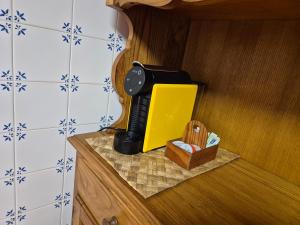 a kitchen counter with a black and yellow appliance on it at Casinha do Pátio in Nogueira do Cravo