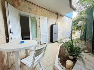 a patio with a white table and chairs and a refrigerator at CasaMare - Numana, comodo trilocale in centro in Numana