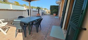 a table and chairs on a patio with a green door at Sirolo Summer Appartamento in Sirolo