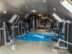 a gym with a blue floor and tread machines at Dwór Kresowy in Radymno