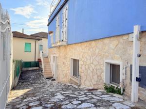 a cobblestone alley in front of a blue building at CasaMare - Numana, comodo trilocale in centro in Numana
