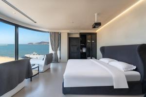 a bedroom with a bed and a view of the ocean at Bay Four Seasons Castle Hotel in Weihai +118 photos