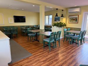 a restaurant with tables and chairs and a flat screen tv at Annapolis Royal Inn & Suites in Annapolis Royal