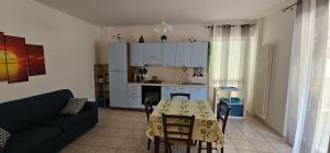 a kitchen and living room with a table and a couch at Sirolo Summer Appartamento in Sirolo