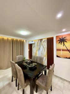 a dining room with a black table and chairs at Tulivu Beach Stays in Jeuri