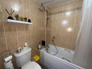 a bathroom with a toilet and a tub and a sink at One bedroom Flat in Birmingham City Centre with free underground parking in Birmingham +35 photos