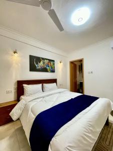 a bedroom with a large bed with a blue blanket at Tulivu Beach Stays in Jeuri