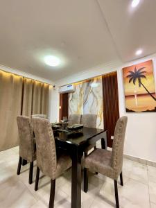 a dining room with a black table and chairs at Tulivu Beach Stays in Jeuri +9 photos