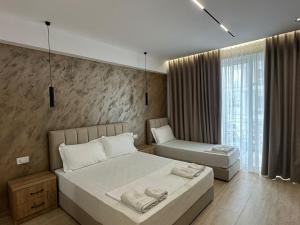 a bedroom with two beds and a window at Moonlight Hotel in Vlorë