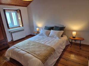 a bedroom with a large bed with two night stands at Casinha do Pátio in Nogueira do Cravo