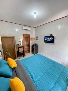 a bedroom with a large blue bed with a tv on the wall at 1 BR Private Studio Apartment with Kitchen in Kerobokan