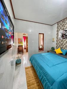 a bedroom with a large blue bed and a tv at 1 BR Private Studio Apartment with Kitchen in Kerobokan