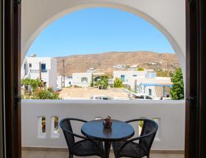 a table and chairs on a balcony with a view at Villa Andromeda in Amorgos