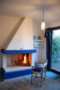 a fireplace in a living room with a chair and a fire place at Villa stella di mare in Capitana