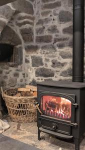 a fireplace in front of a stone wall at Chyvena in Ruan Minor