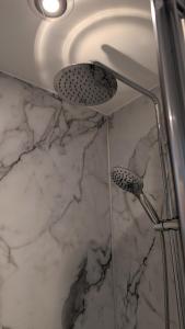 a bathroom with a shower with white marble at Chyvena in Ruan Minor