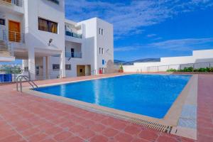 a swimming pool in front of a building at Beach Apartment with Pool Banana Beach Surf Spot in Aourir