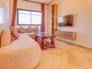 a living room with a couch and a table at Beach Apartment with Pool Banana Beach Surf Spot in Aourir