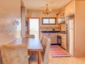 a kitchen with a table and chairs and a refrigerator at Beach Apartment with Pool Banana Beach Surf Spot in Aourir