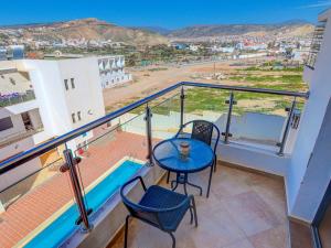 a balcony with a table and chairs and a view at Beach Apartment with Pool Banana Beach Surf Spot in Aourir