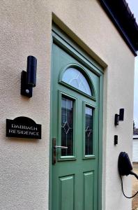 a green door on the side of a building at Dabbagh Residence in Lees