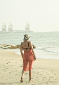 a woman walking on the beach near the ocean at Cocos cabana in Ilandaiyadi +15 photos