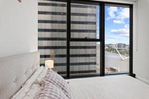 a bedroom with a bed and a large window at CBD Luxury River View & Fireworks 1Bed Apt The One in Brisbane +26 photos