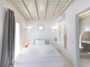 a white bedroom with a bed and a sink at Parfait Villa, Mykonos in Agios Ioannis Mykonos +37 photos