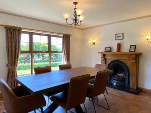 a dining room with a table and chairs and a fireplace at Hill Farm in Dunmore