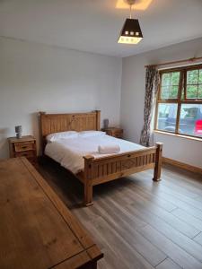 a bedroom with a wooden bed and a window at Hill Farm in Dunmore