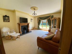 a living room with a couch and a fireplace at Hill Farm in Dunmore