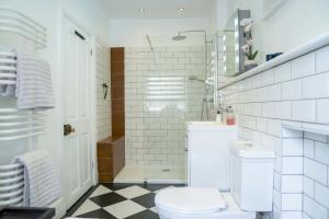 a white bathroom with a toilet and a shower at Sunny Homestay Room, 10 Mins North Laine, 6 Mins Station in Brighton & Hove