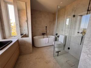 a bathroom with a tub and a shower and a sink at Åh Stifts- & Konferensgård in Ljungskile