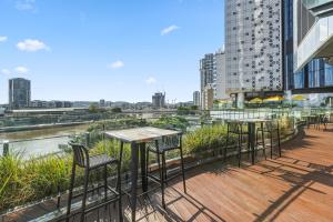 a row of tables and chairs on the balcony of a building at CBD Luxury River View & Fireworks 1Bed Apt The One in Brisbane
