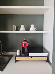 a red appliance sitting on a shelf in a kitchen at Da Me & Te in Ginosa