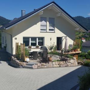 een wit huis met een tafel en een patio bij Ferienwohnung Schwarzwaldblick in Bühlertal