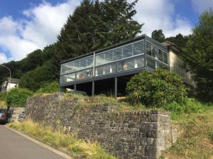 a glass house on top of a stone wall at Eifelloft&Spa in Adenau