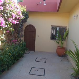 a door in a building with flowers and plants at Appartement Keur Diam Saly in Saly Portudal