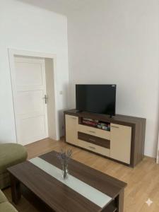 a living room with a television and a coffee table at Stratos Apartments in Laa an der Thaya