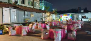 a group of tables with pink and white chairs at Himalaya Pool & Resort Hotel in Tirupati +256 photos