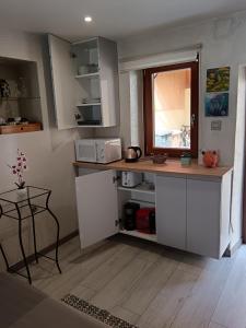 a kitchen with white cabinets and a table and a window at Passage des Romains studio in Horbourg